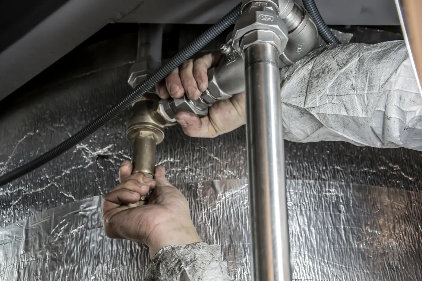 A plumber's hands fitting steel pipework